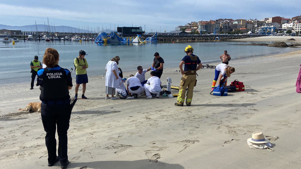 Sanitarios atienden a una mujer en la playa de Baltar, en Portonovo. DP