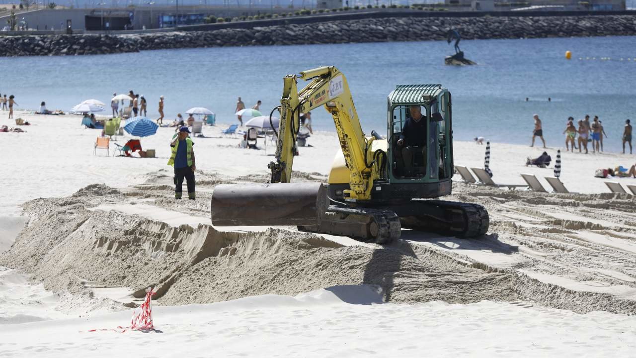 Una excavadora trabajó en la playa junto a los bañístas este fin de semana. JAVIER CERVERA-MERCADILLO